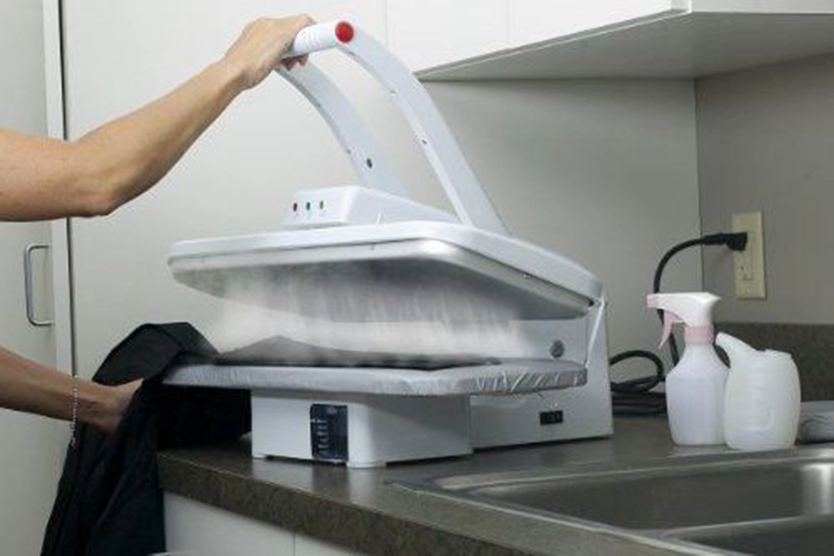 فردی درحال اتو کردن با اتو پرس