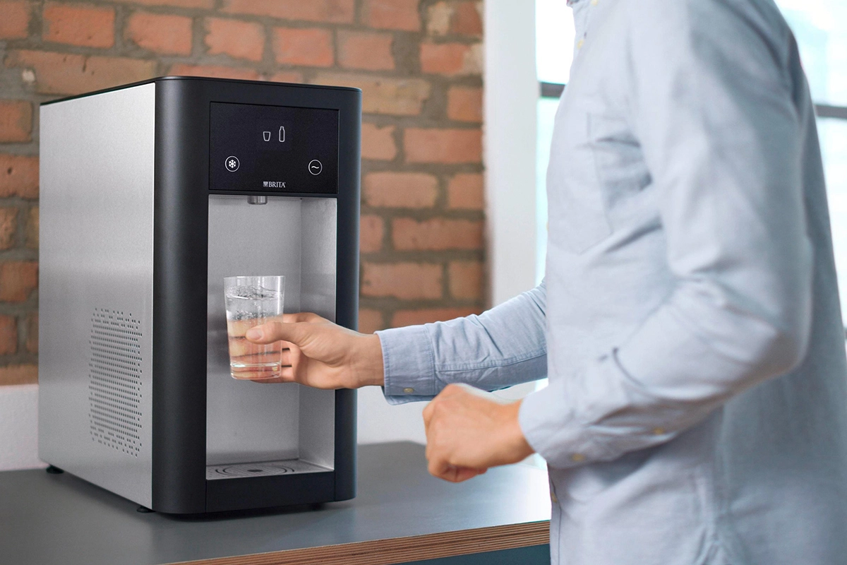 آقایی درحال پرکردن لیوان از آبسردکن