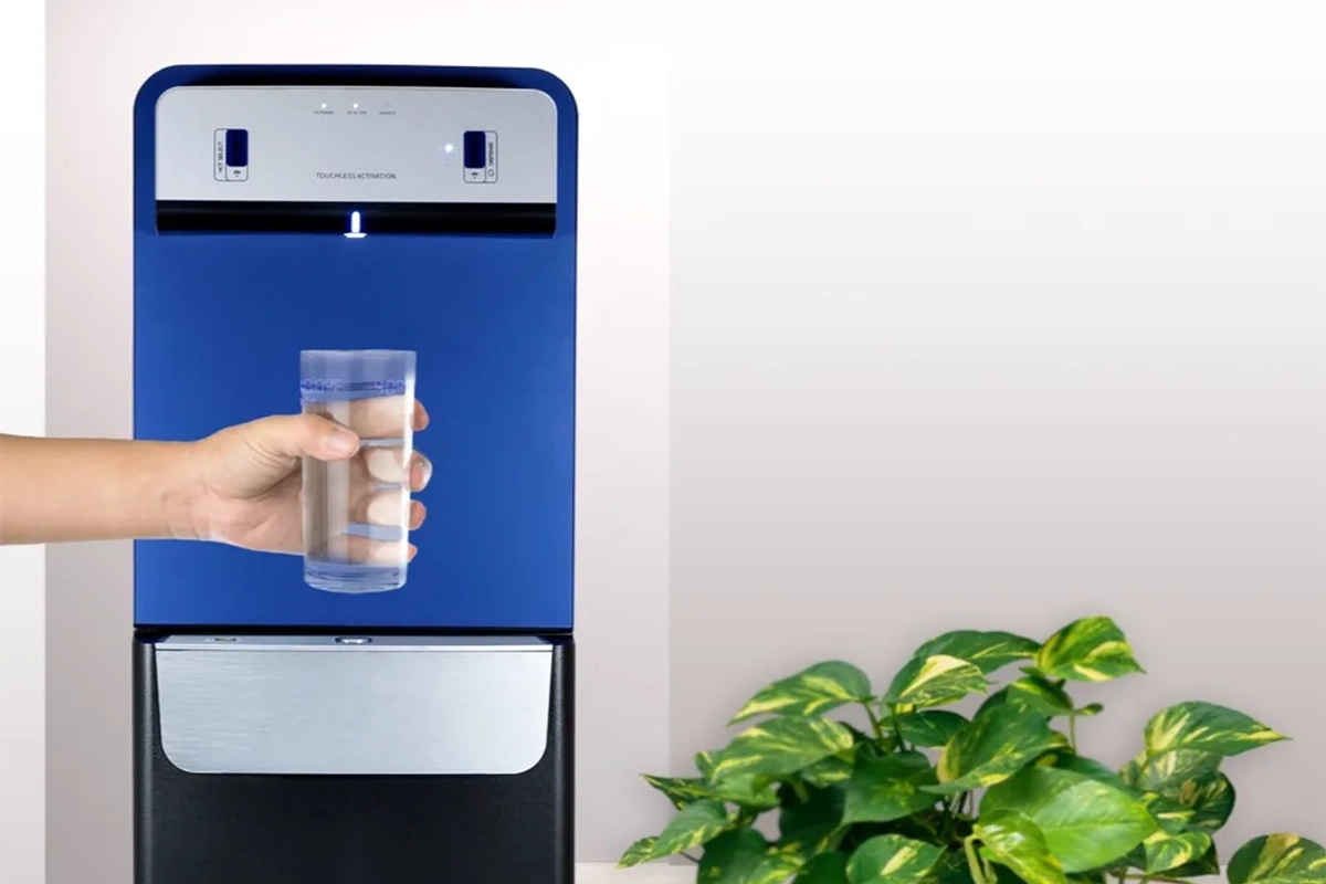 لیوانی پر از آب درون یک آبسردکن و گرفته شده با دست